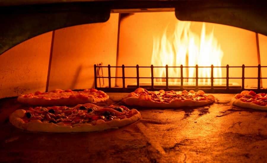Mehrere Pizzen backen im Holzofen